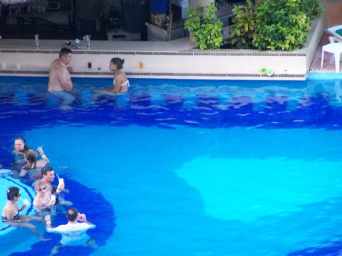 1979 Ford F-150 - A group of people enjoy drinks and conversation while wading in a bright blue swimming pool.