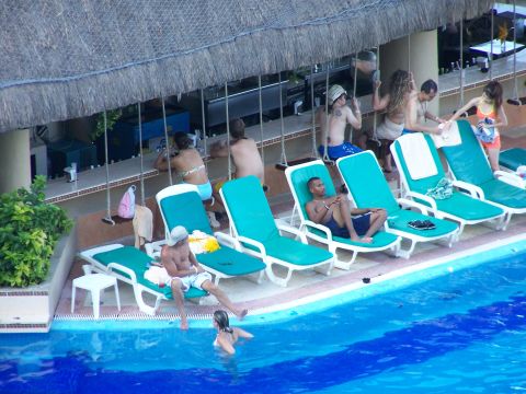 1979 Ford F-150 - A poolside bar scene with several people enjoying the water and lounging.