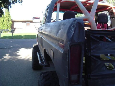 1979 Ford Bronco - Rear view of a modified 1979 Ford Bronco showing body damage and an interior roll cage.