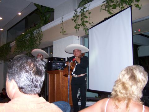 1979 Ford F-150 - A mariachi band performs for an audience in a venue with a large projection screen.