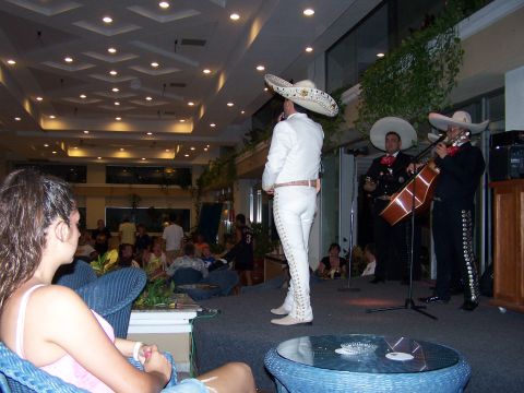 1979 Ford F-150 - A mariachi band plays music on a stage in a brightly lit indoor venue while people watch.