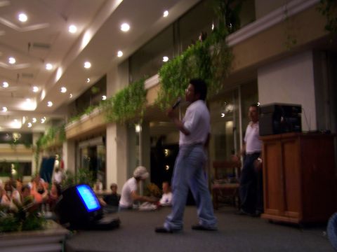 1979 Ford F-150 - A man is on stage speaking into a microphone, with a monitor and audience visible.