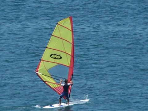 1979 Ford F-150 - A person windsurfing on a body of water with a colorful sail.