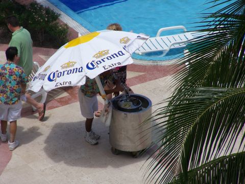 1979 Ford F-150 - A group of people are gathered near a swimming pool, with a Corona-branded umbrella providing shade.