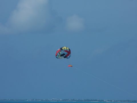 1979 Ford F-150 - Parasailing activity over the ocean with a colorful canopy against a clear blue sky.
