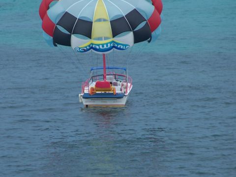1979 Ford F-150 - A boat is being used for parasailing, with the 'Aqua World' logo visible on the parachute canopy.