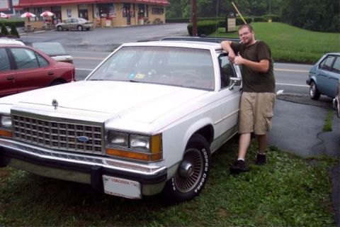 1985 Ford LTD Crown Victoria - White 1985 Ford Crown Victoria LTD parked outside with a man posing next to it. Other vehicles are in the background.