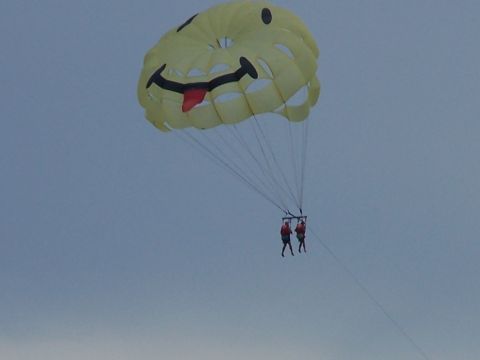 1979 Ford F-150 - Two people are parasailing under a large yellow parachute designed to look like a smiley face.