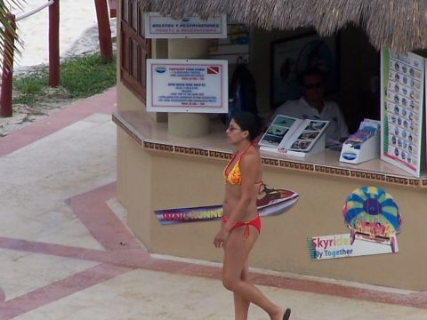 1979 Ford F-150 - A woman walks past a beach resort's ticket and reservation booth, which displays various activity brochures.