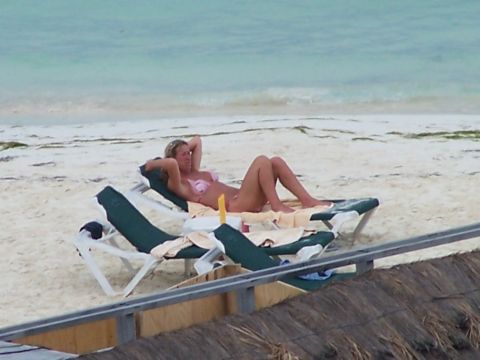 1979 Ford F-150 - Woman relaxes on a beach chair by the ocean, with another chair visible in the foreground.