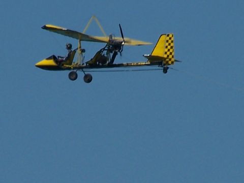 1979 Ford F-150 - An ultralight aircraft flies against a clear blue sky.
