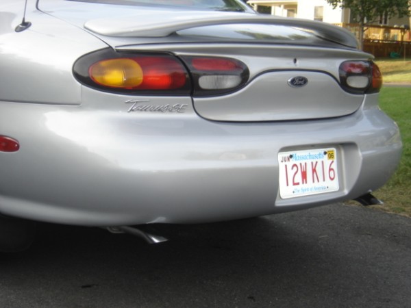 Rear of a silver Ford Taurus sedan showing Massachusetts plate 12WK16 and tail lights