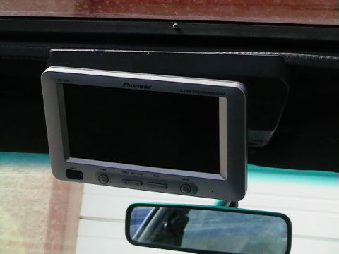 1992 Ford Taurus - A Pioneer screen is mounted above the rearview mirror inside a vehicle.