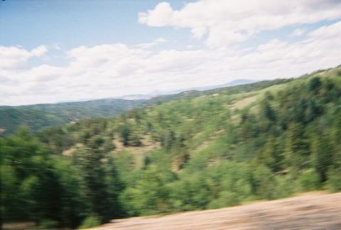 1972 Ford Ranchero - A blurry view of rolling hills and distant mountains under a cloudy sky.