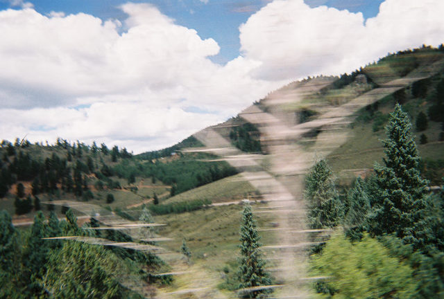 Mountain landscape with trees and clouds, motion blur effect