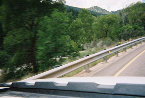 1972 Ford Ranchero - A scenic view from a vehicle traveling on a highway, with trees and mountains in the background.