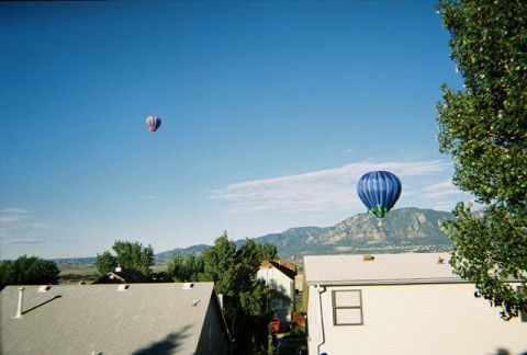 1972 Ford Ranchero - Two hot air balloons drift across a vast blue sky, with mountains and residential rooftops visible below.