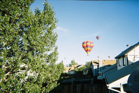 1972 Ford Ranchero - Hot air balloons ascend into the clear blue sky above a suburban neighborhood.