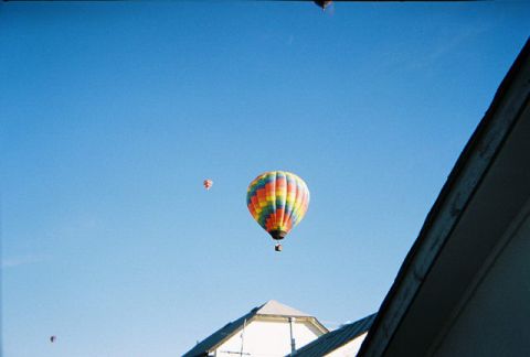 1972 Ford Ranchero - Several hot air balloons ascend into the clear blue sky, with one prominent balloon displaying a vibrant rainbow pattern.
