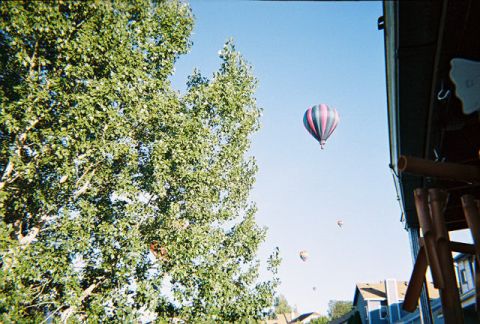 1972 Ford Ranchero - Several hot air balloons ascend into a clear blue sky above a residential area.