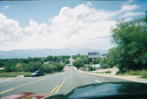 1972 Ford Ranchero - View from inside a car driving on a highway with distant mountains under a cloudy sky.