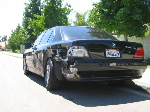 1985 Ford Bronco - This black BMW 740iL shows significant damage to its rear bumper and taillights.