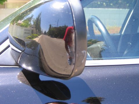 1985 Ford Bronco - Side mirror reflection shows a residential street scene and the car's interior.