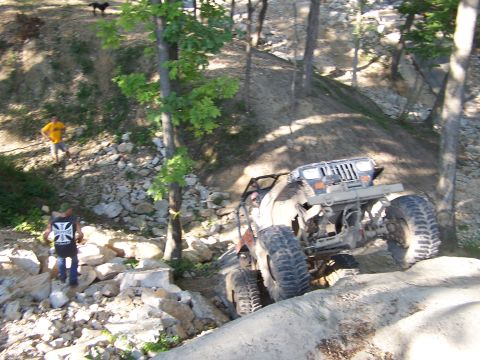 1992 Ford Bronco - A modified Jeep Wrangler navigates a challenging off-road course with steep inclines and rocky terrain.
