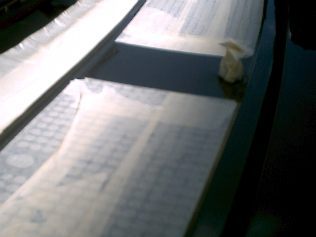 Close-up of weathered black truck cowl and hood with sun-faded paint and handwritten papers