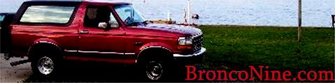 1995 Ford Bronco - This red Ford Bronco, likely from the early to mid-1990s, is parked by the water.