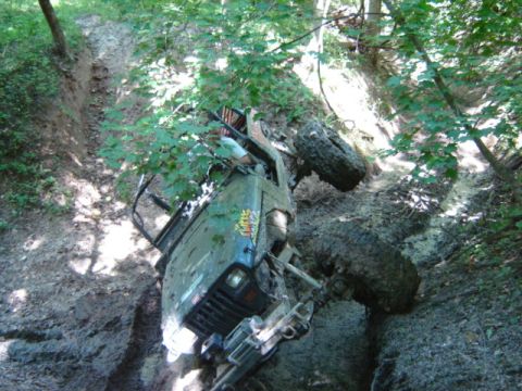 1992 Ford Bronco - This vehicle appears to be stuck and overturned on a steep, muddy trail.