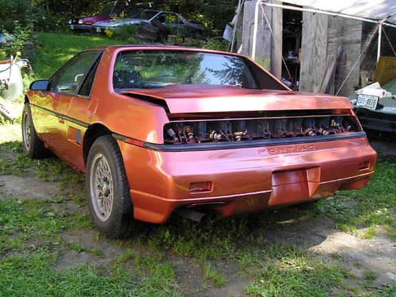 Orange 1984 Pontiac Fiero rear view, engine exposed