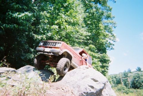 1976 GMC C/K Pickup - This modified pickup truck is navigating a rocky terrain with its front end angled upwards.