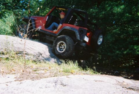 1976 GMC C/K Pickup - Jeep Wrangler navigating a steep, rocky incline during an off-road excursion.