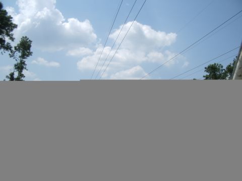 1978 Ford Bronco - A partial view of a vehicle, possibly a 1978 Ford Bronco, is visible against a backdrop of clouds and power lines.