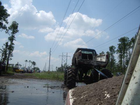1978 Ford Bronco - Monster truck attempts to navigate a muddy terrain with other vehicles nearby.