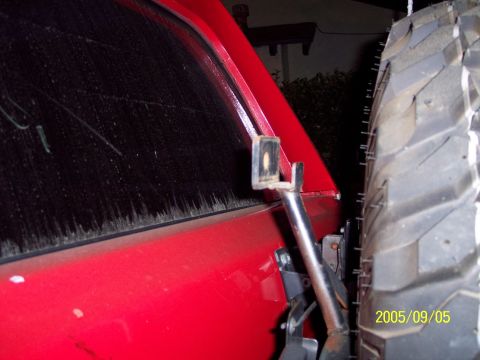 1985 Ford Bronco - Close-up of a red SUV's rear window and spare tire mount, with a date stamp of 2005/09/05 visible.