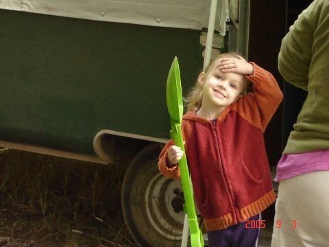 1993 Ford Bronco - A young girl stands next to a trailer, holding a green toy shovel.