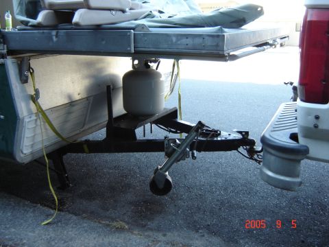 1993 Ford Bronco - A pop-up tent trailer is hitched to a truck, with a propane tank mounted on the trailer tongue.