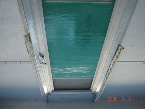 1993 Ford Bronco - The interior of a pop-up tent trailer shows a window with a textured green material and aluminum framing.