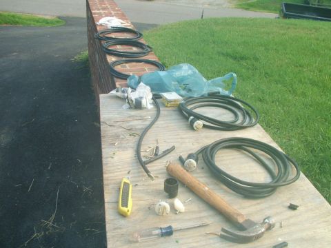 2003 Ford Mustang - Various electrical cords and tools are arranged on a plank of wood outdoors.