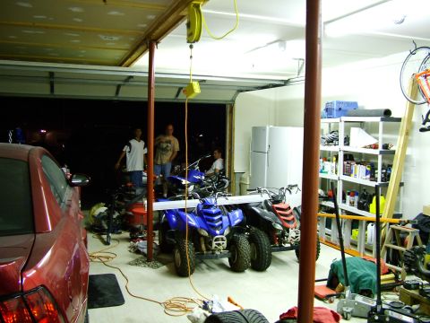 2003 Ford Mustang - Garage scene with multiple vehicles and storage shelves.