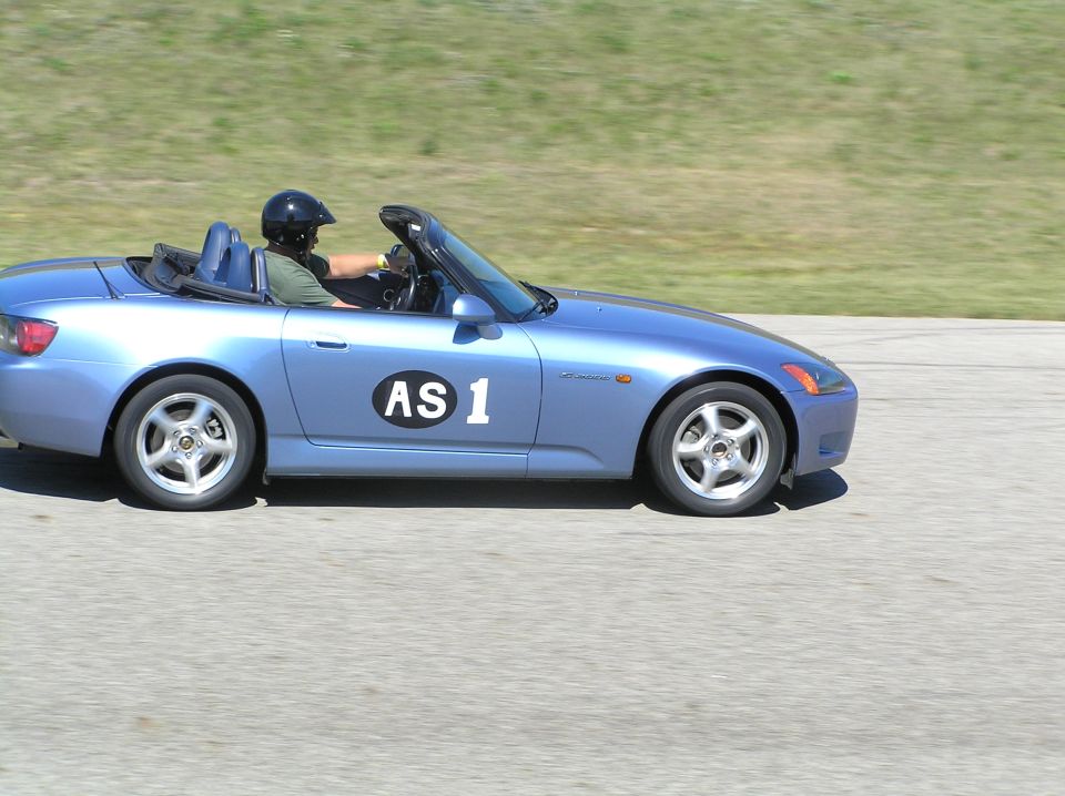 Blue Honda S2000 roadster numbered AS 1 with helmeted driver on track