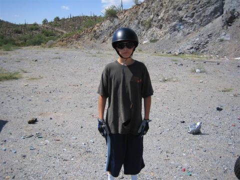 1994 Ford Bronco - A person stands in a desolate, rocky area, wearing a helmet and sunglasses.