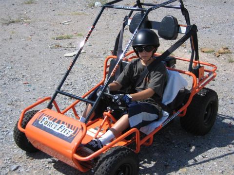 1994 Ford Bronco - A young person is seated in an orange go-kart, ready to drive.