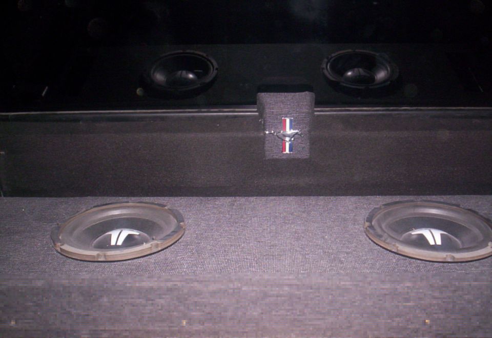 Car audio system with two subwoofers and two smaller speakers, a Mustang emblem