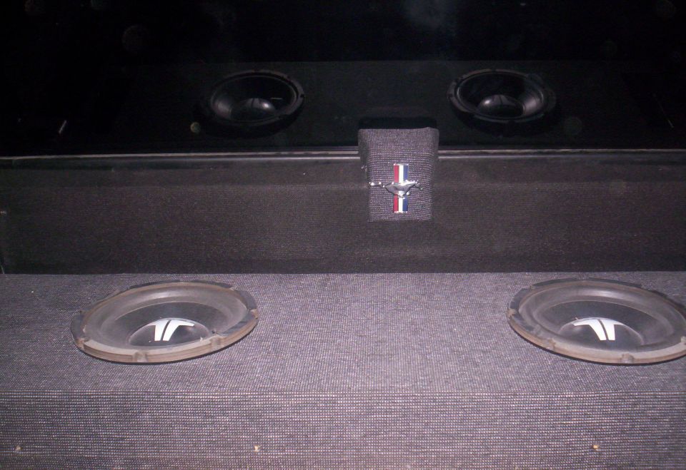 Car audio system with two woofers and two smaller speakers, plus a Mustang emblem