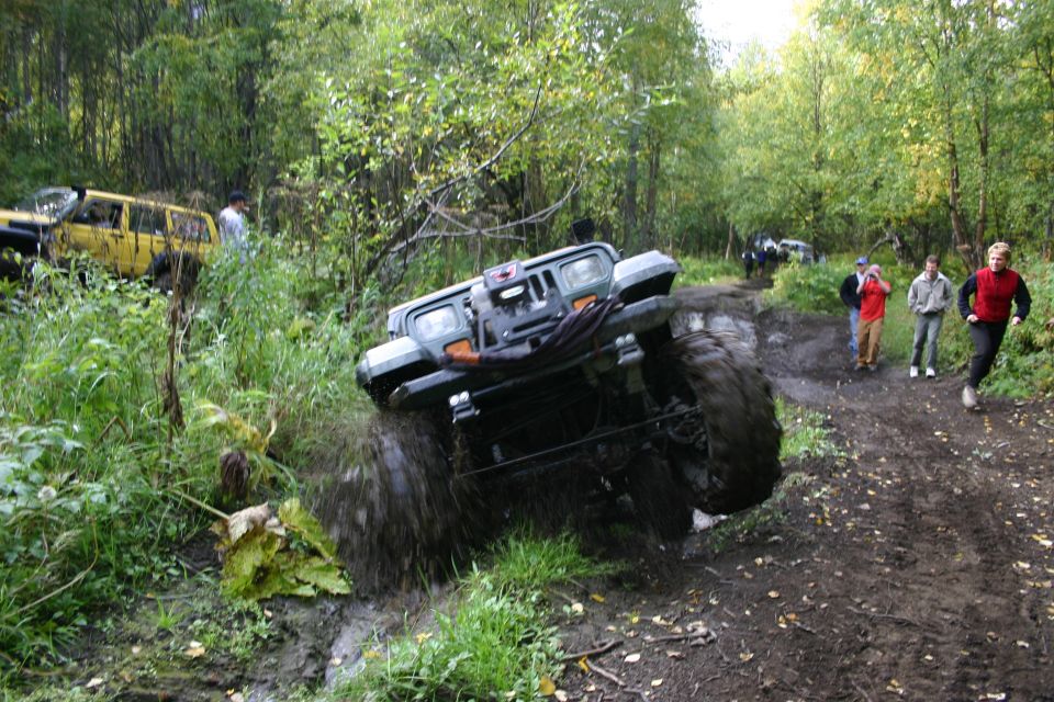 Gray Jeep Wrangler TJ navigating a muddy trail, splashing water