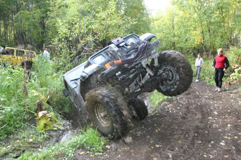 2003 Jeep TJ - An off-road vehicle is stuck in the mud on a trail, with another vehicle in the background.