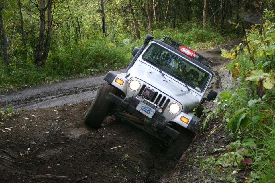 Jeep TJ going off-road on a muddy trail